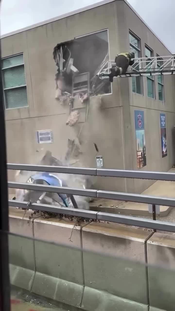   تلاش آتش‌نشان‌ها برای خارج کردن خودرو بعد از پرواز و ورود ناگهانی به طبقه دوم ساختمان از پنجره!