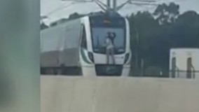 آویزان شدن مرد دیوانه استرالیایی از قطار سریع السیر!